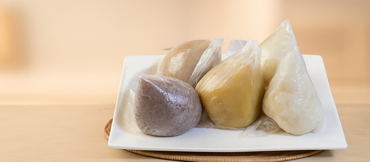 Assorted African swallows—eba, amala, fufu, and semolina—wrapped and arranged on a serving plate.